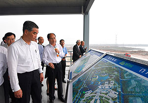 于肇庆新区砚阳湖观景平台听取该区发展的介绍。