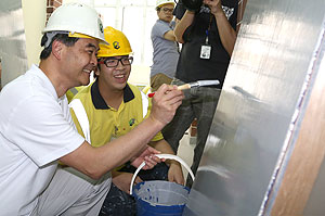 梁振英参观油漆粉饰科工场，在学员「指导」下尝试扫油漆。