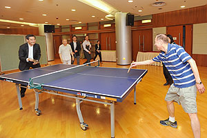 Mr Leung takes on one of the residents at table tennis in the activity room.
